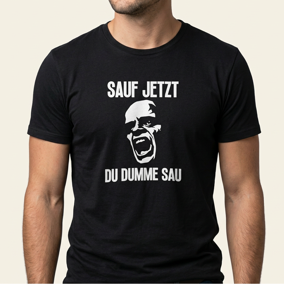 Mann trägt schwarzes Saufshirt mit Frontprint „Sauf jetzt du dumme Sau" und schreiendem Gesicht