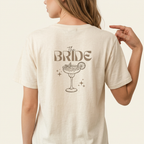 The Bride Shirt in Gold mit Cocktailglas-Motiv als Rückenprint für den JGA