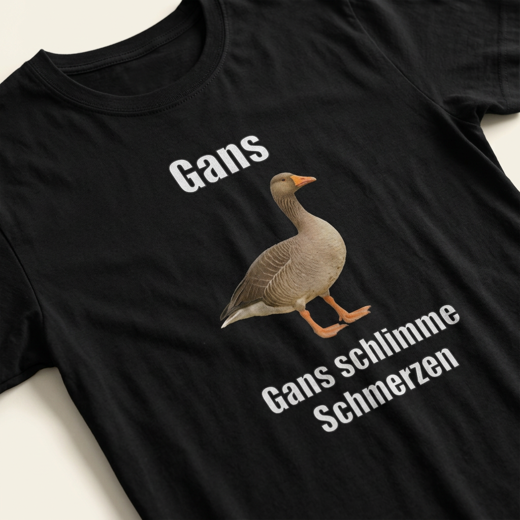 Detailaufnahme des Gänse-Motivs mit Spruch „Gans schlimme Schmerzen" auf schwarzem Baumwoll-T-Shirt